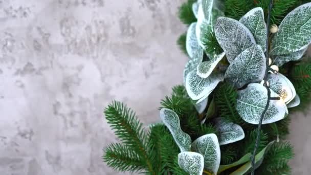 Dekorativní listoví v jiných na jehličnatých větvích. Dekorativní vánoční věnec zdobený uměle zdobenými stříbrnými květy. Vysoce kvalitní 4K záběry — Stock video