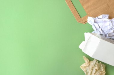Yeşil arka planda kağıt çöpü. Geri dönüşüm ve çevreyi koruma kavramı. Yatay konum, düz konum, metin için boşluk