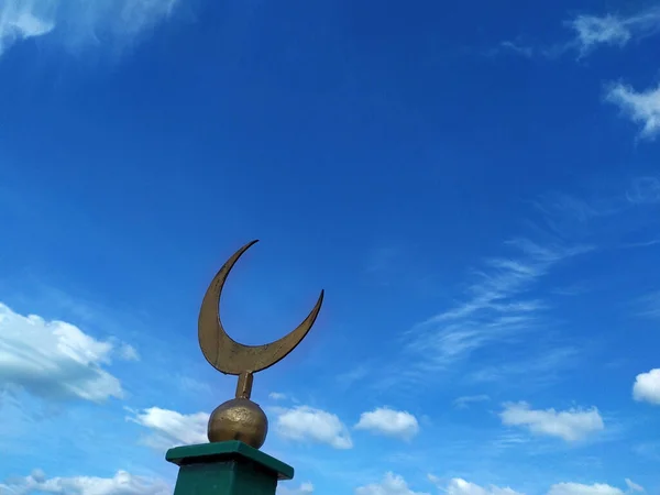 Symbol of Islam and Islam is a crescent moon on a pillar. Against a blue sky with white clouds. Religion. Faith-inscrutable. Copy space for text. Background