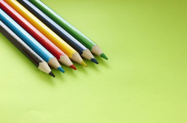 Sarı arka planda renkli kalemler. Bir sürü farklı renkli kalem. Renkli kalem. Kalemler keskindir. Kalemler sağ üst köşede. Yakın plan. Uzayı kopyala Geçmişi. Düz yatıyordu.