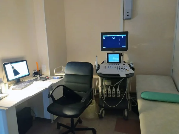 Tıbbi teşhis ekipmanları, muayene için kanepe, doktorun iş yeri. Ultrasonik tanı cihazı. Monitör mavi. Teşhisler. Doktorun ofisi. Tıbbi konu. Metin için alanı kopyala.