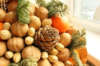 Hediye Noel buketi. Çam kozalakları, portakallar, fıstıklar, cevizler, ladin dalları güzel bir pakette. Seçimlere odaklan. Yılbaşı ve yeni yıl temadır. Tatil teması. Geçmişi. Yiyecekler. Yukarıdan görüntüle.