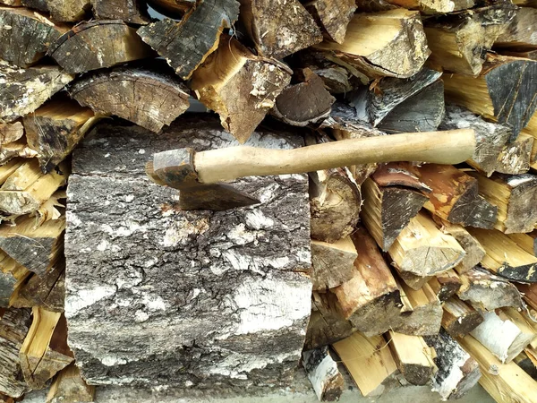 Abstract photograph of piles of natural wooden logs. Background. An axe is stuck on the big stump. Harvesting firewood for the winter. Texture. View from above. Wood for the fireplace. Birch boards — Stock Image Abstract Photograph Piles Natural Wooden Logs Background Axe Stuck Big Royalty Free Stock Photos