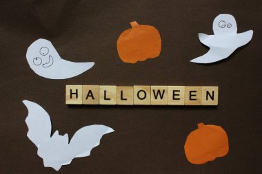 Cadılar Bayramı. Siyah arkaplanda yazılı tahta bloklar yarasalar, balkabağı ve kağıt hayaletlerle süslenmiş. İlan tahtası. Tatil kavramı Halluin 'dir. Yukarıdan bak. Boşluğu kopyala