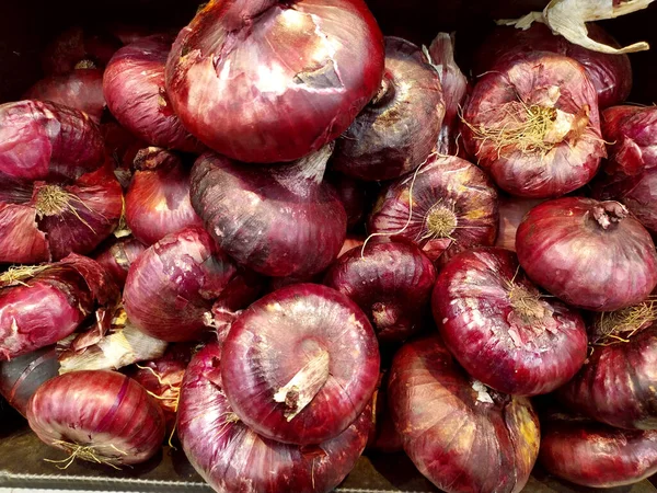 Red onion. Fresh purple onion as a background. Close-up. Texture. Background. Onion background. Ripe onion. Onions on the market. Vegetables.