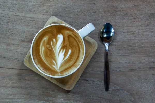 Taza blanca de café con leche en el escritorio de madera, el tiempo ya ha sido enjo — Foto de Stock