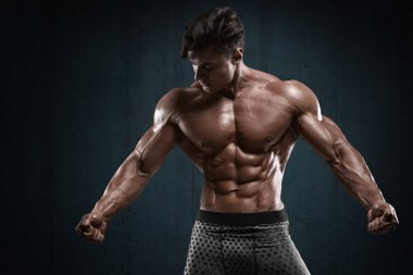 Yakışıklı kaslı adam duvar arka planda, karın şeklinde. Güçlü erkek çıplak gövde abs