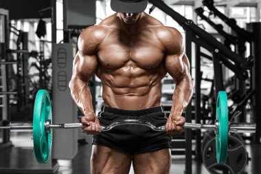 Kaslı adam ile halter için pazı, güçlü erkek çıplak gövde abs egzersizleri yapıyor spor salonunda egzersiz