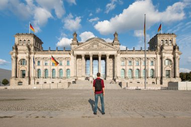 Berlin'de, Almanya'nın Berlin kentinde bina Bundestag bakarak turist adam yola
