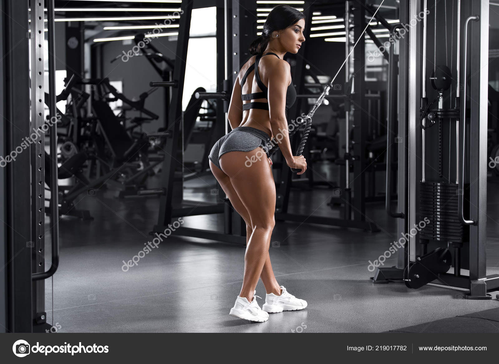 Fitness woman working out in gym. Athletic girl with muscular back