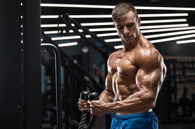 Kaslı adam pazı, güçlü erkek çıplak gövde abs egzersizleri yapıyor spor salonunda egzersiz