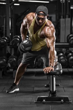Kaslı adam için sırt egzersizleri yapıyor spor salonunda çalışma dışarı. Tek kol Dumbbell satır