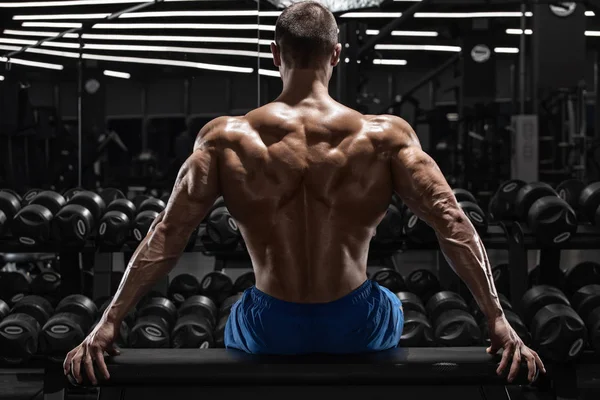 后视肌肉男子在健身房显示背部肌肉 强壮的男性裸体躯干 — 图库照片
