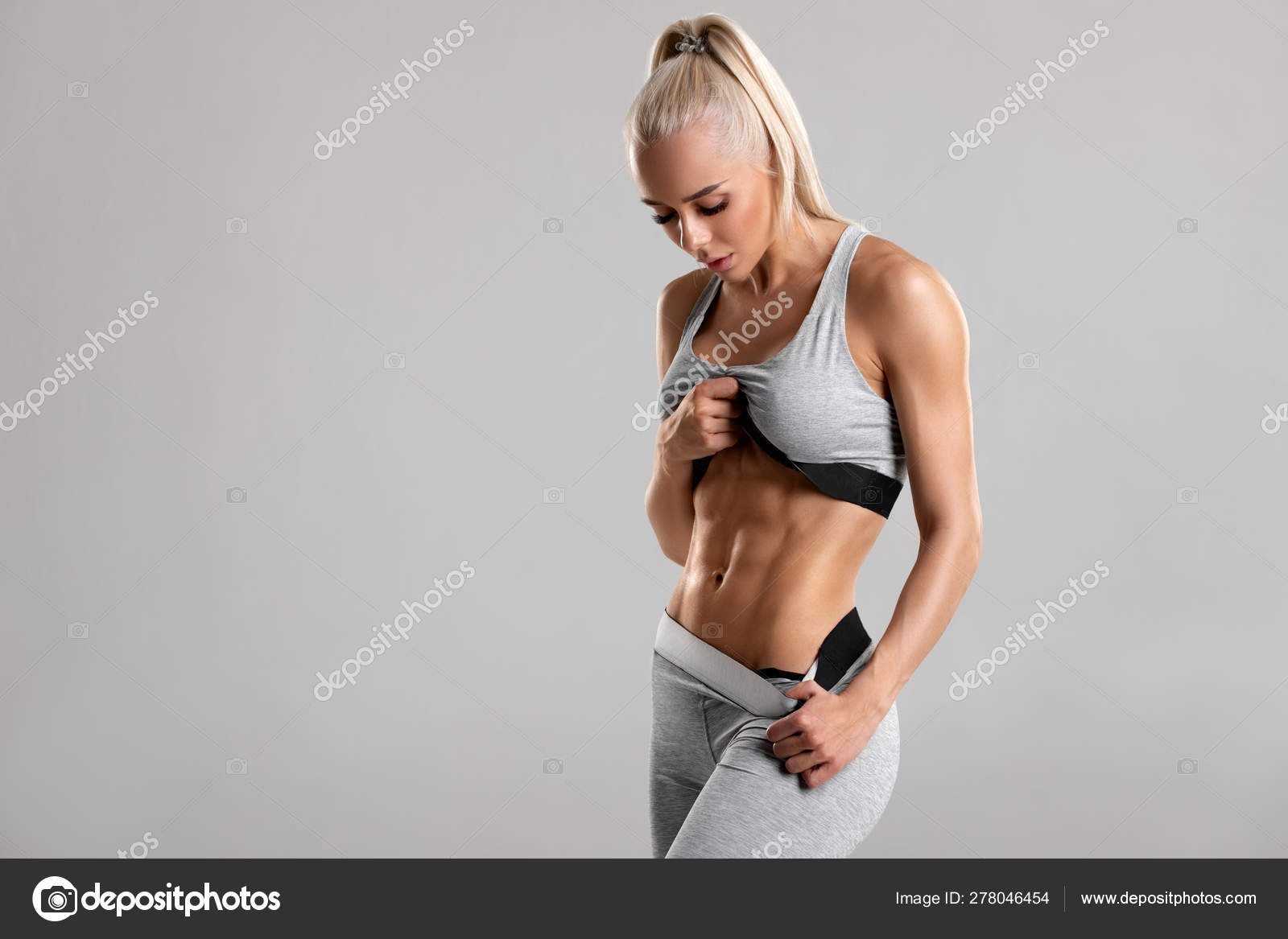 Beautiful fitness woman. Athletic girl on the gray background Stock Photo