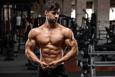 Spor salonunda kaslı adam egzersiz. Güçlü erkek çıplak gövde abs