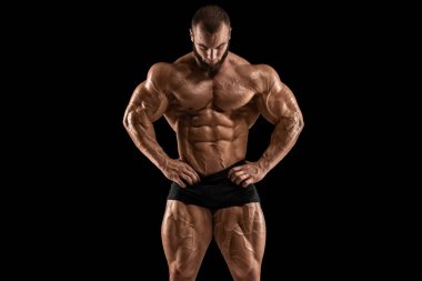 Kaslarını gösteren kaslı adam, siyah arka planda izole edilmiş. Bodybuilder erkek çıplak gövde abs