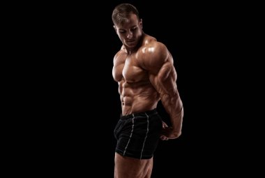 Siyah arka planda kaslı bir adam var. Güçlü erkek çıplak gövde kasları