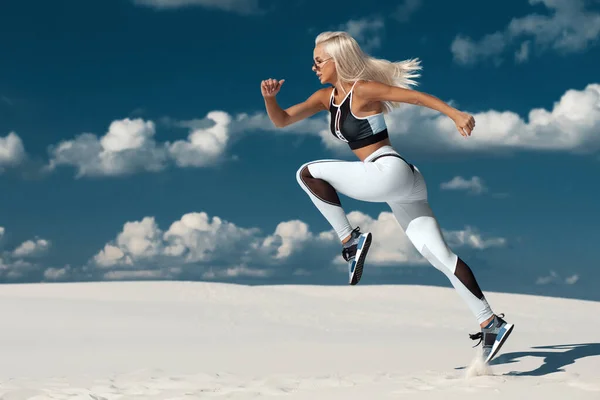 Fitness woman jumping and running on sky background. Athletic girl working out