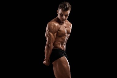 Siyah arka planda izole olmuş kasları gösteren kaslı bir adam. Güçlü erkek çıplak gövde kasları