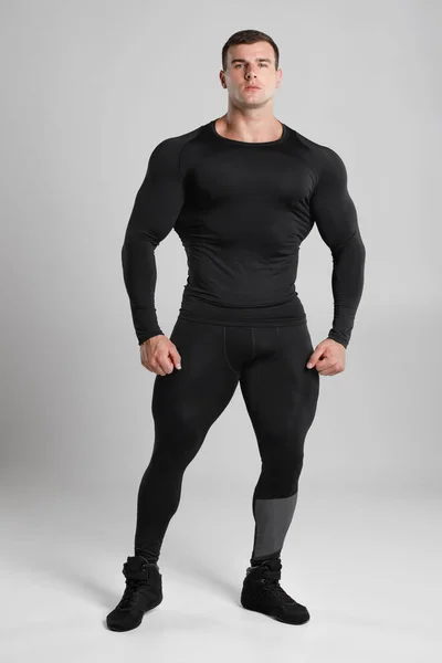 Hombre Musculoso Ropa Deportiva Compresión Negra Sobre Fondo Gris —  Fotos de Stock