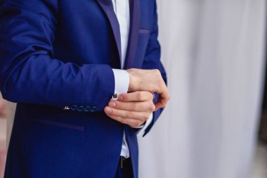 Pencere kenarındaki beyaz gömlekli adam. Kol düğmeleri.