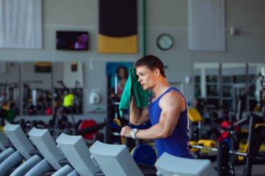 Spor salonunda antrenmandan sonra havluyla antrenman yapan adam.