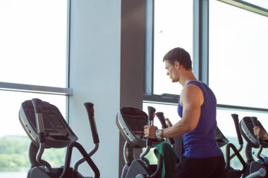 Güçlü bir adam, vücut geliştirici spor salonunda egzersiz yapıyor.