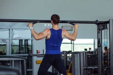 Güçlü bir adam, vücut geliştirici spor salonunda egzersiz yapıyor.