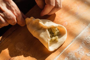 Son sınıf öğrencisi kadın mutfağındaki masada turta hazırlıyor.