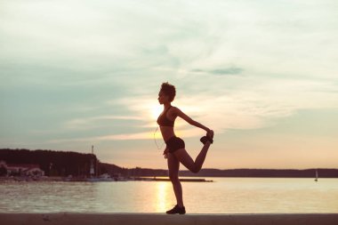 Çekici genç Afrikalı atlet kız gün batımında ya da plaj boyunca gün doğumunda koşuyor. Koşucunun spor eğitimi.