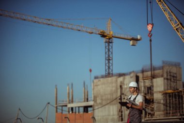 İnşaat mühendisi, inşaat alanındaki nesnelerin tablet resimlerine sahip.