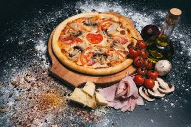 Jambonlu, mantarlı, domatesli lezzetli pizza.