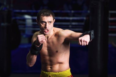 Spor: Erkek boksör boks salonunda tekme pratiği yapıyor.