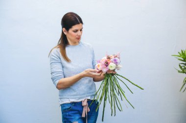 İşteki çiçekçi: farklı çiçeklerden modern buket yapan kadın