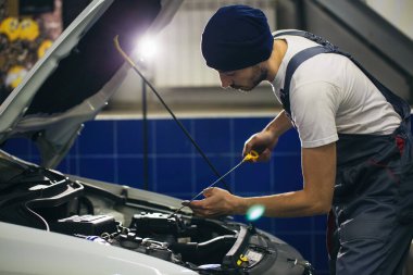 Otomobil tamircisi motor yağını otomobil istasyonundaki bir motora dönüştürüyor.