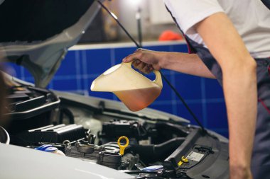 Otomobil tamircisi motor yağını otomobil istasyonundaki bir motora dönüştürüyor.