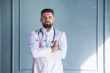 Boynunda steteskopla kameraya bakan bir doktor.