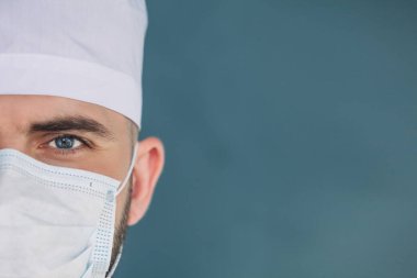 Sağlık sigortası, tıbbi konsept, erkek cerrahın yüzü, yakın çekim. Sağlık subayı kameraya bakar.