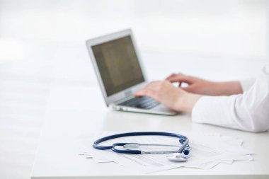 Tablet kullanan, tıbbi form ve belgelerle teşhis koyan kadın doktor. Kapat.