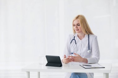 Samimi doktor, bilgisayar tabletinin kamerasına bakıyor ve olumlu teşvik veriyor.