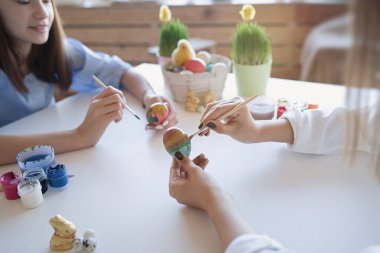                                Mutlu ergenler kız arkadaşları evde renklilerle ve fırçayla yumurta boyuyor. Paskalya, tatiller ve insanlar konsepti       