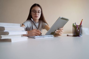                                Masada kitap okuyup ödev yapan tatlı bir genç kız. Eğitim, çocuklar ve okul kavramı    
