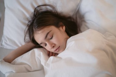                          Evdeki beyaz yastıkta uyuyan tatlı genç kız.          