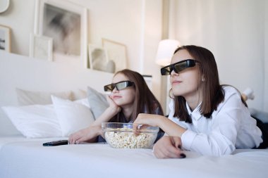             Mutlu arkadaşlar ya da gözlüklü genç kızlar evde patlamış mısır yiyip film izliyorlar.                    