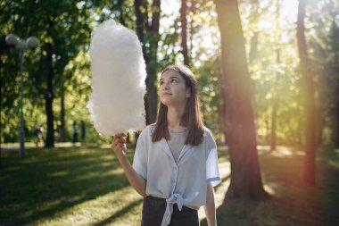                                Parkta pamuk şeker yiyen güzel bir kızın portresi.    