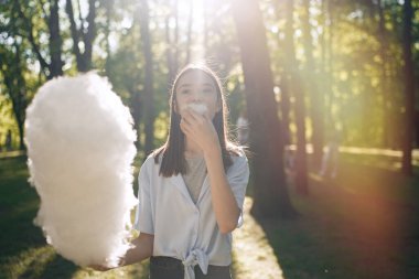                                Parkta pamuk şeker yiyen güzel bir kızın portresi.    