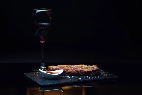 Smaklig Nötkött Biff Och Ett Glas Rött Vin Svart Bakgrund — Stockfoto