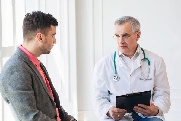 Kıdemli doktor genç hastaya danışıyor.