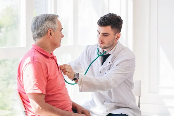 Kıdemli adam bir doktor tarafından muayene ediliyor.