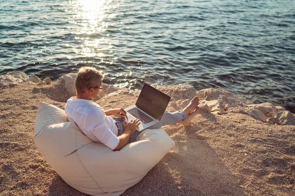 Senior Man Working His Laptop Lying Deck Chair Beach Sunset — Stock fotografie